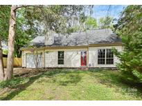 Inviting one-story home with a manicured lawn and an attached garage, set beneath mature trees at 10432 Camelback Cir, Charlotte, NC 28226
