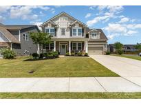 Charming two-story home featuring a welcoming front porch and a well-manicured lawn, perfect for curb appeal at 11234 Smokethorn Nw Dr, Concord, NC 28027