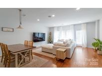 Bright living room features a dining area and a plush sectional couch by a large window at 12036 Duke Lancaster Dr, Charlotte, NC 28277