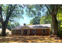 Charming brick ranch home featuring a well-manicured lawn and mature trees at 211 Worthington St, Shelby, NC 28150