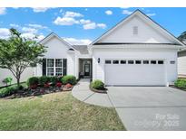 Charming single-story home with manicured lawn, mature landscaping, and attached two-car garage at 5039 Folly Ln, Fort Mill, SC 29707