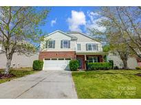 Charming two-story home with a brick and vinyl exterior, attached garage, and well-maintained lawn at 517 Bertram Rd, Fort Mill, SC 29708
