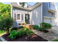 Inviting home entrance featuring a landscaped garden and a classic front door, with sidelight and hanging light at 6013 Coaching Inn Ct, Charlotte, NC 28270