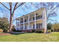 Stately two-story home with a columned front porch and second-story balcony, offering classic Southern charm at 8600 Peyton Randolph Dr, Charlotte, NC 28277