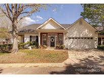 Charming single-story home with brick and white siding, attached garage, and well-manicured lawn at 8603 Bookwalter Ct, Charlotte, NC 28277