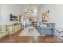 Spacious living room featuring hardwood floors, a soaring ceiling, and stylish decor at 8603 Bookwalter Ct, Charlotte, NC 28277