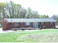 Charming single-story brick home with a well-maintained front yard, featuring a blend of mature trees at 9716 Sunway Dr, Mint Hill, NC 28227