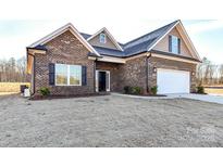 Charming brick home featuring a two-car garage, manicured landscaping, and a welcoming front entrance at 1259 Archer Loop St # 73, Waxhaw, NC 28173