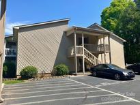 Inviting condo exterior with stairs to entrance, car parking, and attractive landscaping at 140 Lake Concord Ne Rd # D-1, Concord, NC 28025