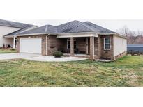 Charming brick home featuring a well-maintained lawn and a cozy front porch with seating at 1643 Mayfair Dr, Conover, NC 28613