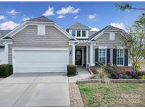 Charming home featuring a two-car garage, manicured landscaping, and a welcoming front porch entrance at 20202 Dovekie Ln, Indian Land, SC 29707