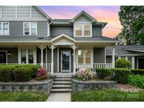 Charming home featuring a welcoming front porch with decorative columns and beautiful landscaping at sunset at 2756 Von Thuringer Ct, Charlotte, NC 28210