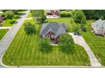 Expansive brick home with lush green lawn and mature trees on a well manicured lot from an aerial perspective at 3011 Patrick Place Cir, Clover, SC 29710
