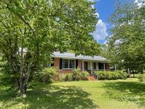 Charming single-story brick home with a well-maintained front yard and mature trees at 309 E Stevens Rd, Kershaw, SC 29067