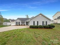 Charming single-story home featuring well-maintained landscaping and inviting curb appeal with grey siding at 4147 Timberwood Dr, Gastonia, NC 28056