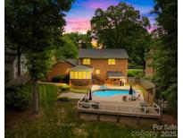 Inviting backyard with pool, patio, and outdoor kitchen perfect for entertaining under the sunset at 6744 Wheeler Dr, Charlotte, NC 28211