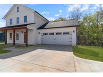 Close up of an attached white garage with black accents and a concrete driveway at 7205 Church Rd, Taylorsville, NC 28681