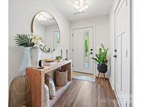 Bright entryway with modern light fixture, stylish decor, and wood-look flooring at 7324 Swans Run Rd, Charlotte, NC 28226