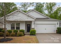 Charming home featuring a two-car garage, stone accents and well-manicured landscaping enhancing its curb appeal at 7518 Porrera St, Charlotte, NC 28214