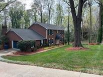 Charming two-story brick home featuring a well-manicured lawn and lush landscaping at 815 21St Avenue Nw Dr, Hickory, NC 28601