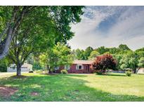 Charming brick ranch home with a well-maintained lawn, mature trees, and a detached garage on a sunny day at 904 Sunbeam Dr, Lincolnton, NC 28092