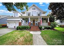 Charming two-story white home with a brick porch, manicured lawn and meticulous landscaping at 908 Gardenia St, Fort Mill, SC 29708