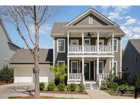 Charming two-story home featuring a double porch, well-manicured landscaping, and a two-car garage at 107 Iris Meadow Dr, Mooresville, NC 28115