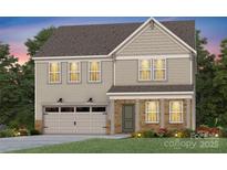 Two-story home with a front-entry garage and a covered entry with brick pillars, set against a sky at dusk at 13709 Roderick Dr # 193, Huntersville, NC 28078