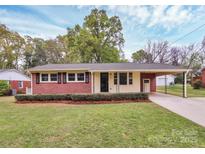 Charming brick home featuring a well-maintained front yard, black shutters, and an attached carport at 140 Mickle Ct, Rock Hill, SC 29732