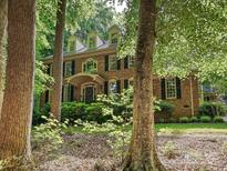 Charming brick home featuring mature trees, a landscaped front yard, and elegant architectural details at 2313 Beechwood Dr, Waxhaw, NC 28173