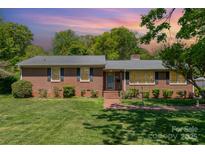 Charming brick home with manicured lawn, inviting walkway, and mature trees showcasing curb appeal at 3000 Imperial Dr, Gastonia, NC 28054