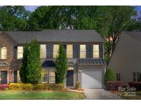 Charming two-story home with well-maintained landscaping, shutters, and an attached garage in a tree-lined neighborhood at 3214 Park South Station Blvd, Charlotte, NC 28210