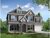 Charming two-story home showcasing a stone facade, shingle accents, and an inviting covered entryway and manicured lawn at 7211 Farmingdale Ln # 42, Harrisburg, NC 28075