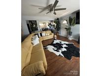 Bright living room with a tan leather sectional sofa and decorative plants at 110 Buffalo Nw Ave, Concord, NC 28025