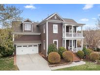 Charming two-story home with a two car garage, manicured landscaping, and inviting double-decker porch at 11204 Arlen Park Dr, Huntersville, NC 28078