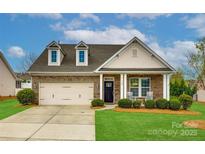 Charming brick home with a two-car garage, dormer windows, a well-manicured lawn, and rocking chairs on the front porch at 1129 Black Walnut Rd, Clover, SC 29710