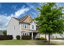 Two-story home with a two-car garage, complemented by a lush green lawn at 15225 Kissimmee Ln, Mint Hill, NC 28227