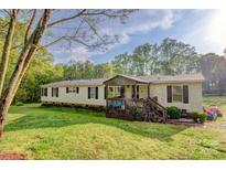 Inviting single-story home features a covered porch, well-maintained lawn, and mature trees surrounding the property at 2006 Kollege Ln, Crouse, NC 28033