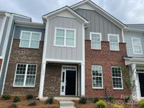 Front exterior of townhome with brick facade, gray siding, and black front door at 534 Dorman St, Belmont, NC 28012