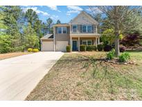 Charming two-story home with a two-car garage, lovely landscaping, and a welcoming front porch at 6010 Hawk View Rd, Waxhaw, NC 28173