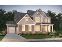 Charming two-story home featuring a covered porch, attached garage, and well-manicured front yard at 14205 Kershaw Cir # 13, Huntersville, NC 28078