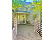 Inviting front entrance featuring a covered porch with seating and views of the surrounding greenery at 14613 Waterside Dr, Charlotte, NC 28278