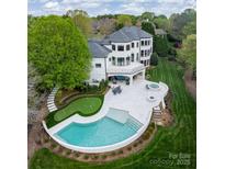 Stunning aerial view of backyard featuring in-ground pool, putting green, spa, patio and manicured lawn at 15603 Mccullers Ct, Charlotte, NC 28277