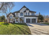 Elegant two-story home boasts a pristine lawn, dual garage, and bright white brick facade at 18038 Greyfield Gln, Fort Mill, SC 29707