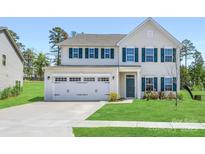 Charming two-story home featuring a two car garage, manicured lawn, and complementary green shutters at 2018 Sewall Sw Ave, Concord, NC 28025