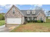Charming home featuring a stone and vinyl exterior, attached two-car garage, and well-maintained landscaping at 2408 Joes Lake Rd, Shelby, NC 28152