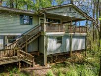 Charming cottage-style home featuring a wooden deck and two sets of exterior wooden staircases, set amongst mature trees at 322 Electra Ln, Stanley, NC 28164