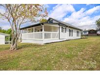 Charming home featuring a covered porch, white siding, dark shutters, and a yard with flowering tree at 382 Cole Campbell Rd, Taylorsville, NC 28681