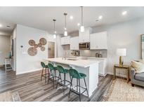 Bright kitchen boasts white cabinetry, an island with seating, and modern pendant lighting at 7144 Hodges Meadow Ln, Charlotte, NC 28213