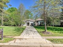 Charming single-story home features a well-manicured lawn, mature trees, and long driveway leading to the entrance at 11447 Egrets Point Dr, Charlotte, NC 28278